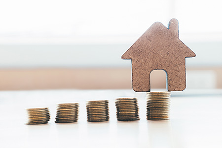 Soft focus of House and Golden Coins Stacks with blur Background.Savings Plans for Housing,Finance and Banking about House concept.