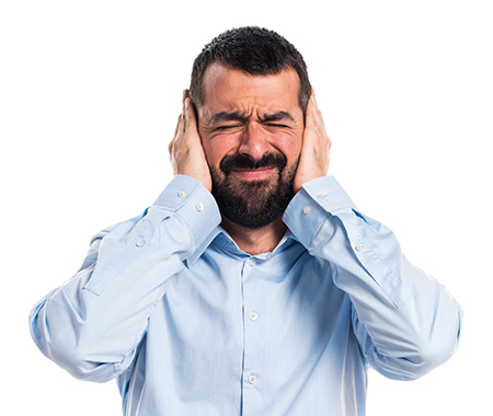 Man with laptop covering his ears